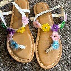 White sandals with plasticc colored flowerss